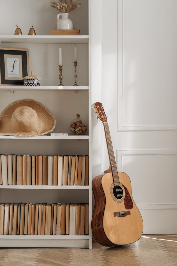 An inviting interior featuring an acoustic guitar leaning against a bookshelf filled with books and decor.